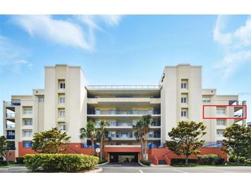 Beautiful condominium complex with lush landscaping, covered parking, and blue balcony railings at 5300 S Atlantic Ave # 6-507, New Smyrna Beach, FL 32169
