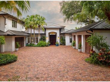 Stunning home featuring a brick driveway, lush landscaping, and a grand entrance at 9724 Chestnut Ridge Dr, Windermere, FL 34786
