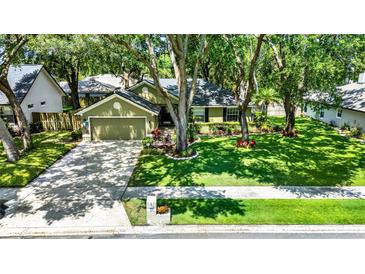 Charming home features lush lawn, mature trees, tidy landscaping, and a two-car garage at 1608 Victoria Way, Winter Garden, FL 34787