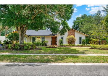 Charming single story home with a manicured lawn, mature trees and inviting curb appeal at 1390 Yellow Pine Ct, Winter Springs, FL 32708