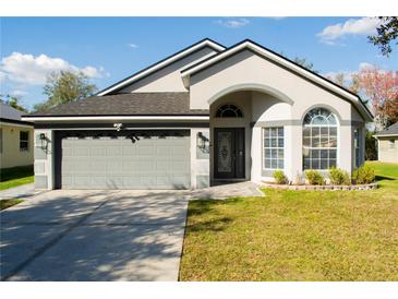 Charming single-story home featuring a grey two-car garage and well-manicured lawn at 149 Southampton Dr, Kissimmee, FL 34744