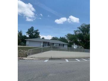 Single story home with gray siding, light colored roof, white railing, and a partial view of the front yard at 2233 N Normandy Blvd, Deltona, FL 32725
