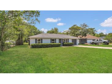 Charming single-story home featuring a lush green lawn and beautiful landscaping enhancing curb appeal at 250 Hickory Ave, Orange City, FL 32763