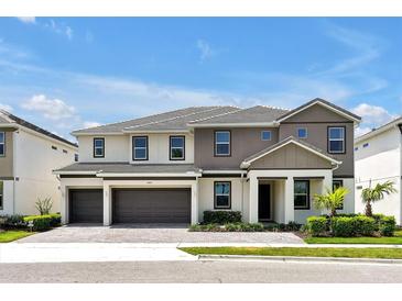 Beautiful two-story home showcasing neutral paint, a three-car garage, manicured landscaping, and a tile roof at 3860 Sonoma Blvd, Kissimmee, FL 34741