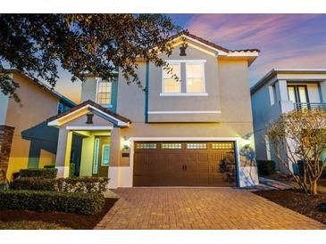 Charming two-story home featuring a brick driveway, two-car garage, and manicured landscaping at 640 Lasso Dr, Kissimmee, FL 34747