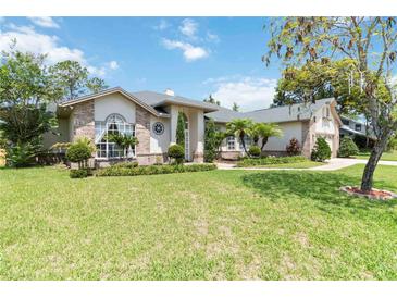 Charming home featuring manicured landscaping, a lush lawn, and brick accents at 802 Kaywood Dr, Orlando, FL 32825