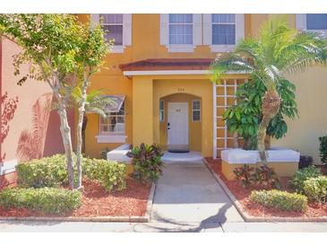 Charming yellow two-story home with well-maintained landscaping and a welcoming front entrance at 944 Park Terrace Cir, Kissimmee, FL 34746