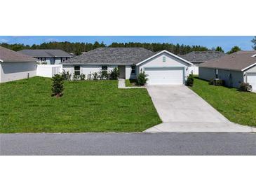 Charming single-story home with a well-maintained lawn and a two-car garage at 15476 Sw 34Th Court Rd, Ocala, FL 34473