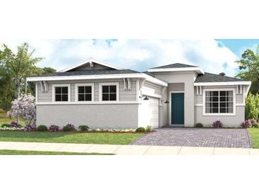Charming single-story home featuring a gray exterior, well-manicured lawn, and a beautifully paved driveway at 1618 Bellagio Loop, Tavares, FL 32778