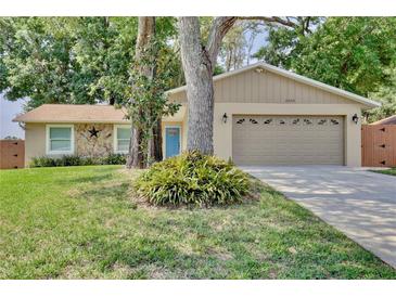 Charming single-story home featuring a well-manicured lawn, stone accents, and a two-car garage at 2320 Wekiva Ridge Rd, Apopka, FL 32712