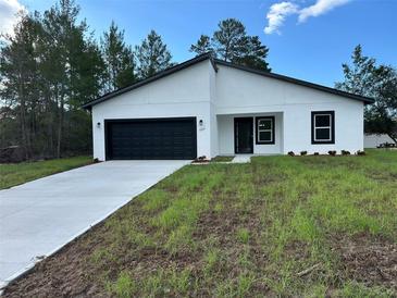 Charming single-story home features a black garage door and a well-manicured lawn at 3063 Sw 168Th Loop, Ocala, FL 34473