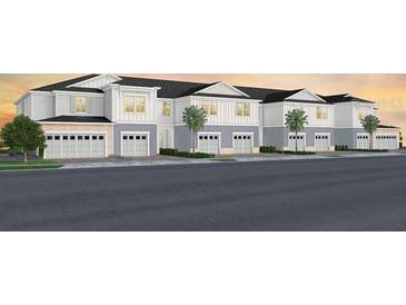 New townhome building showing multiple units with attached garages and landscaping at 405 Meadowland Pt, Oviedo, FL 32765