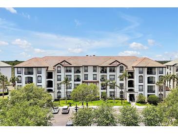 Beautiful condominium building with a tile roof, manicured landscaping, and ample parking at 4114 Breakview Dr # 30702, Orlando, FL 32819