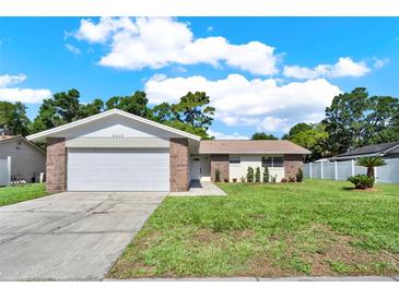 Charming single-story home featuring brick accents, a two-car garage, and a well-manicured lawn at 5210 Poinsetta Ave, Winter Park, FL 32792