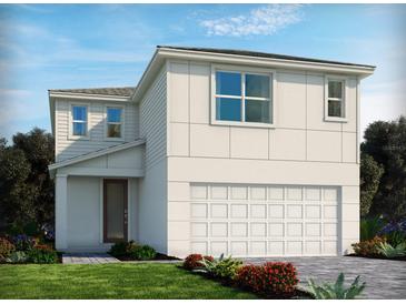 Modern two-story home featuring a two-car garage, clean lines, and lush landscaping at 1127 Cumberland Trail Dr, Lake Hamilton, FL 33851