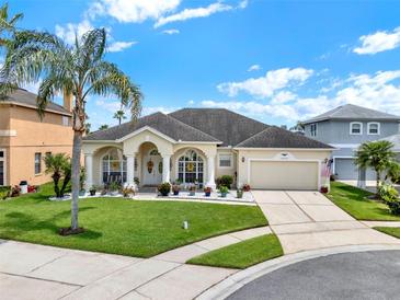 Charming single-story home with a manicured lawn, palm tree, and a welcoming front porch with decorative columns at 14036 Cherry Bush Ct, Orlando, FL 32828