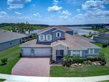 Stunning two-story home with a three-car garage, beautiful landscaping, and a view of the lake at 16768 Sanctuary Dr, Winter Garden, FL 34787