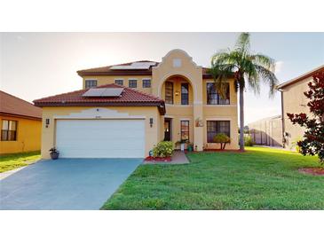Inviting two-story home with a tile roof, lush lawn, and well-manicured landscaping at 3044 Camino Real S Dr, Kissimmee, FL 34744