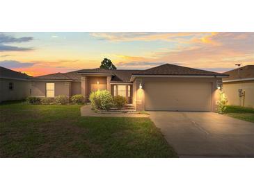 Charming single-Gathering home with manicured lawn and attached two-car garage at sunset at 351 Cloverdale Rd, Winter Haven, FL 33884