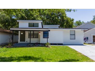 A modern house with a front porch, green lawn, and vibrant landscaping offers great curb appeal at 415 S Lancelot Ave, Orlando, FL 32835