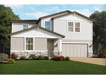 Charming two-story home with gray siding, stone accents, manicured lawn, and an attached two-car garage at 4549 Windy Oak Way, St Cloud, FL 34772