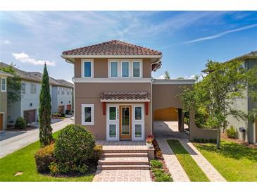 Charming two-story home featuring a lovely portico, arched car port, clay tile roof and beautiful landscaping at 8268 Bellow St, Orlando, FL 32827