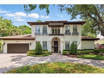 Stately two-story home featuring a terracotta roof, arched windows with flower boxes and lush landscaping at 1361 Palmer Ave., Winter Park, FL 32789