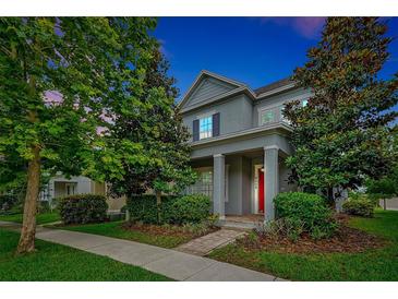 Charming two-story home featuring lush landscaping and a welcoming red front door at 14208 Shocklach Dr, Winter Garden, FL 34787