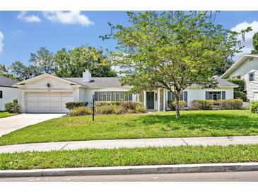 Charming single-story home with a well-manicured lawn, mature tree, and a two-car garage at 2040 Mohawk Trl, Maitland, FL 32751