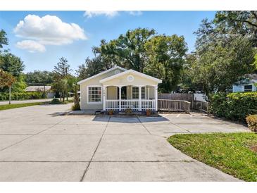 Charming one-story home with a welcoming front porch, manicured lawn, and ample parking space at 205 S Highland Ave, Apopka, FL 32703