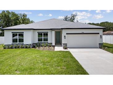 Charming single-story home with well-manicured lawn and attached two car garage on a sunny day at 3944 Sw 130Th Loop, Ocala, FL 34473