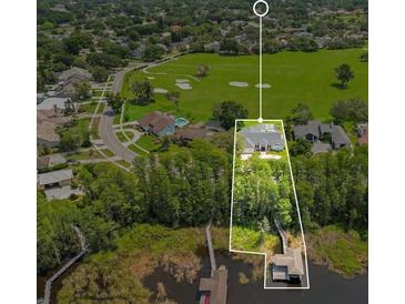 Stunning aerial view of lakeside home with boat dock and golf course access at 5913 Masters Blvd, Orlando, FL 32819