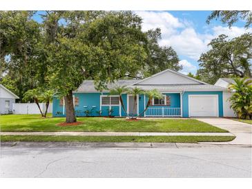 Charming blue single Gathering home with a well manicured front lawn and mature trees at 9014 Great Sound Dr, Orlando, FL 32827
