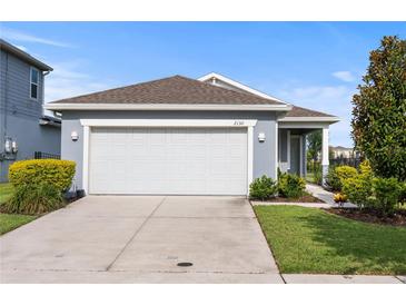 Charming one-story home featuring a two-car garage, well-maintained landscaping, and a welcoming facade at 2130 Bur Oak Blvd, St Cloud, FL 34771