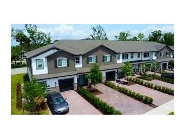 Beautiful townhouse exterior with brick driveways, manicured landscaping and attached garages at 391 Cape Honeysuckle Pl, Sanford, FL 32771