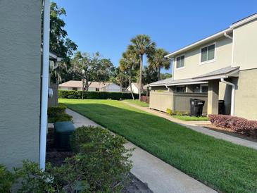 A well-maintained condo exterior with lush green lawn and manicured landscaping on a sunny day at 4596 Pheasant Run Dr # C, Orlando, FL 32808