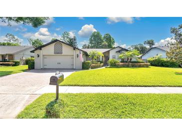 Charming home featuring a lush lawn, mature landscaping, and a brick driveway at 623 Tuskawilla Point Ln, Winter Springs, FL 32708