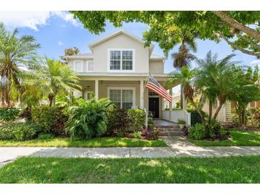 Charming two-story home with a lush garden, an American flag, and a welcoming front porch at 7003 Cupseed Ln, Harmony, FL 34773