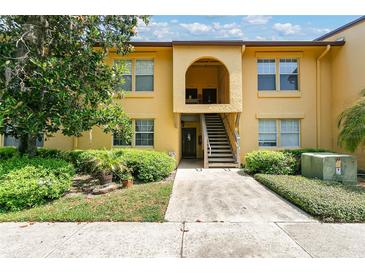 Inviting two-story condo featuring well-maintained landscaping and a charming arched entryway at 758 E Michigan St # 203, Orlando, FL 32806