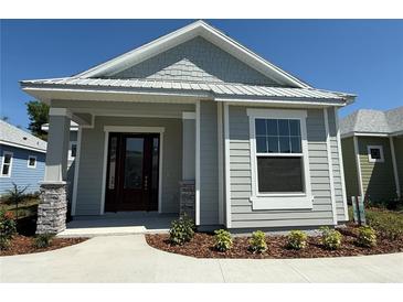 Charming single-story home showcasing stone accents, gray siding, and manicured landscaping at 931 Azalea Walk Cir, Deland, FL 32724