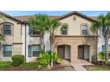Inviting townhouse featuring a red tile roof, front landscaping, and charming entryway at 1943 Majorca Dr, Kissimmee, FL 34747