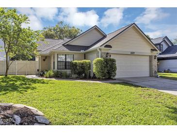 Charming single-story home with a well-manicured lawn and attached two-car garage at 2227 Doulton Dr, Orlando, FL 32812