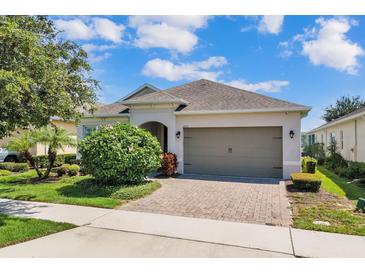 Charming home featuring a well-maintained lawn, a brick driveway, and an attached two-car garage at 2233 Antilles Club Dr, Kissimmee, FL 34747