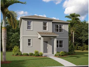 Charming two-story home with gray siding, lush landscaping, and a welcoming front porch at 2365 Zuni Road, St Cloud, FL 34771