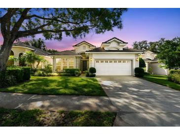 Charming single-story home featuring a well-manicured lawn, mature trees, and a two-car garage at 404 Sotheby Way, Debary, FL 32713