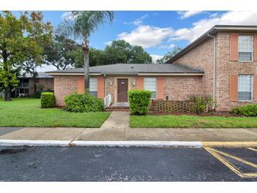 Charming brick home with lush lawn, featuring a palm tree and colorful peach shutters at 416 Banyon Tree Cir # 108, Maitland, FL 32751