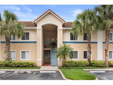 Inviting condo exterior showcasing lush landscaping, palm trees, and well-maintained facade at 527 Villa Del Sol Cir # 104, Orlando, FL 32824