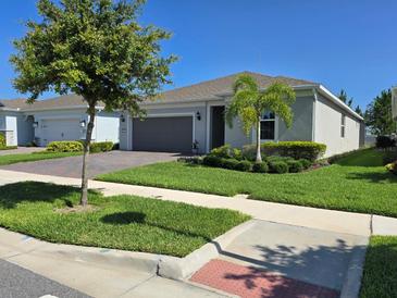 Charming single-story home featuring a well-manicured lawn, mature trees, and a two-car garage at 6129 Citrus Grove Ct, St Cloud, FL 34771