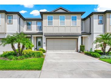 Charming two-story townhouse with attached two-car garage and well-manicured landscaping at 652 Benoi Dr, Davenport, FL 33896