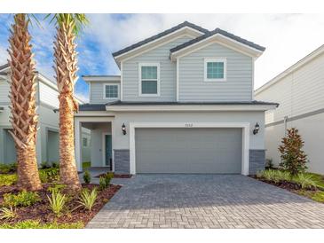 Charming two-story home features a gray color scheme, manicured landscaping and a two car garage at 7352 Oakmoss Loop, Davenport, FL 33837